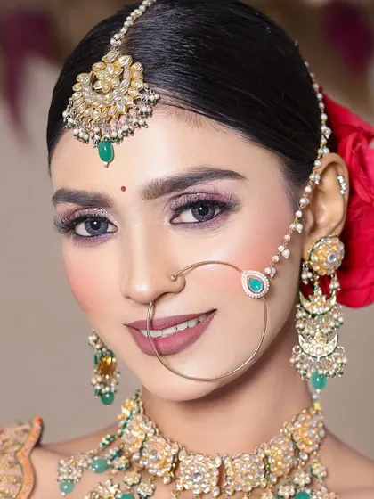 This student created a vibrant look with pink glitter eyeshadow and a bold lip, perfectly complementing the peach and green lehenga.