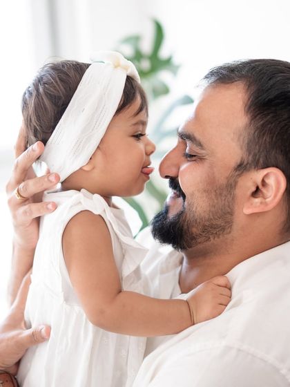 A father and daughter sharing a silly, playful moment.