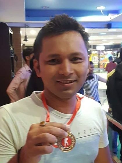 This participant holds up his medal, a token of his skill and precision during his time at our archery range.