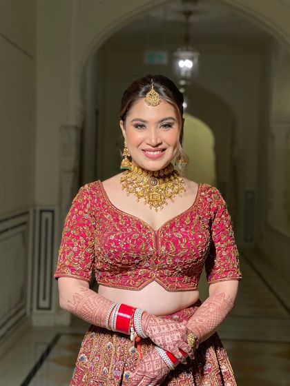 A happy bride showing off her final look. The textured bun with fresh flowers is both traditional and modern, making it a versatile choice for any bride.