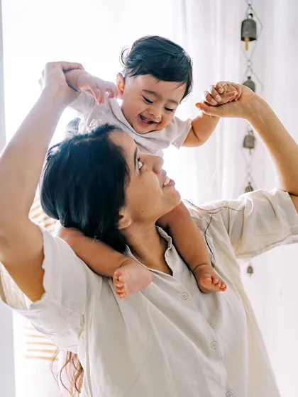 A mother lifting her laughing nine-month-old onto her shoulders. These playful, interactive shots are always full of joy.