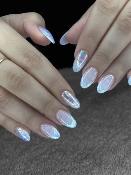 A simple and beautiful set of oval nails with a sheer base and a holographic, iridescent glitter top coat.