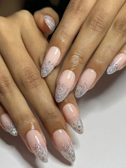 A delicate and dreamy look with a soft pink base and a fade of fine silver glitter at the tips of these long stiletto nails.