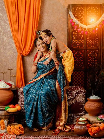 A playful and loving portrait of a mother and her son in his Krishna costume.