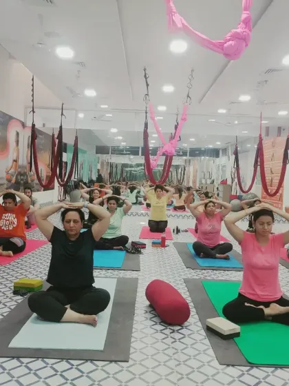A group of students practicing a pranayama technique together in the studio. Focused breathing is a cornerstone of our classes, helping to center the mind before and after asana practice.