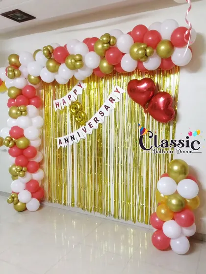 A festive 8th-anniversary decoration for a home party. This setup includes a balloon arch framing a gold shimmer curtain, with a banner and heart-shaped foil balloons.