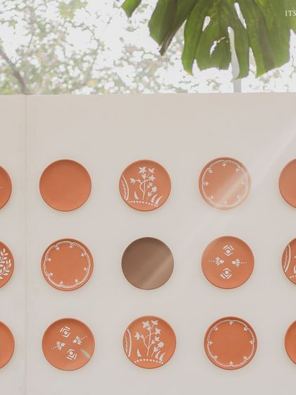 A wall decorated with hand-painted terracotta plates, creating a unique and artistic feature.