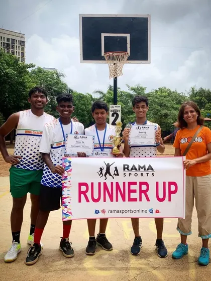 A coach stands with the runner-up team, celebrating their achievement in the tournament.