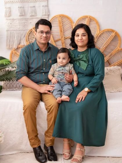 A classic family photo with coordinated outfits. The deep teal and earthy tones create a sophisticated and harmonious look.