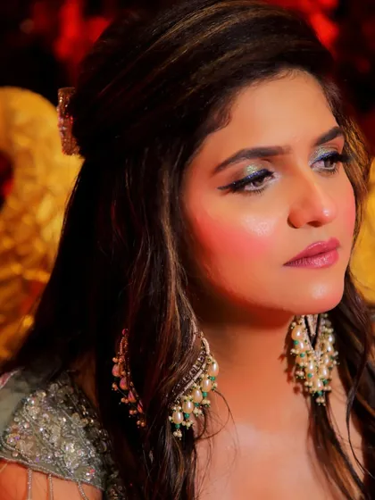 An artistic close-up of the bride's face, focusing on the dramatic and colorful eye makeup for her Mehendi.
