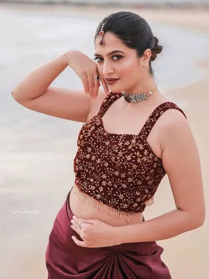A confident and stylish pose on the sand, this shot highlights the unique draped skirt and embroidered top.