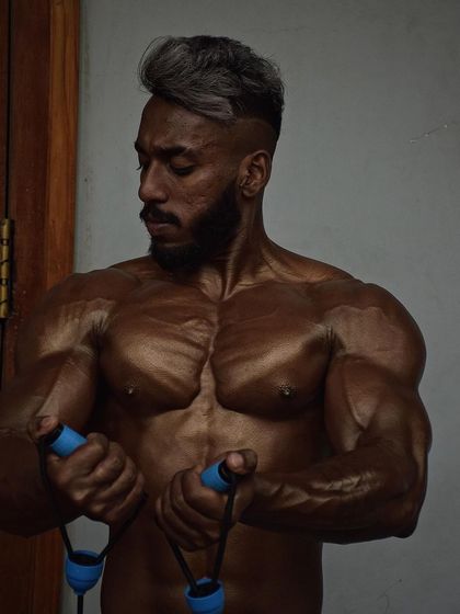 A shot of a client pumping up backstage. The chest striations and vascularity are signs that he is ready for the stage.