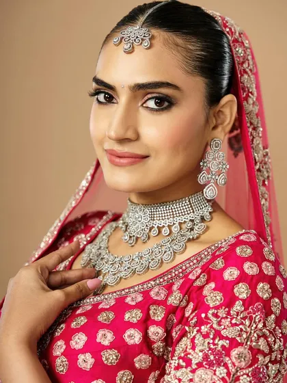 A beautiful smile from a stunning bride. The makeup is kept fresh and bright, with a pop of pink on the lips to match her outfit and a subtle glow on the skin.