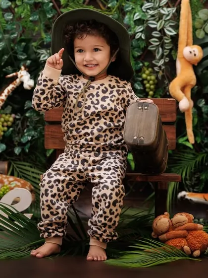 This one-year-old explorer points up, excited about his jungle surroundings during his themed photoshoot.