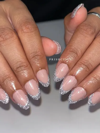 Reflective Frenchies are so much fun. This look features a classic French tip shape, but filled in with a super sparkly silver reflective glitter on acrylic extensions.