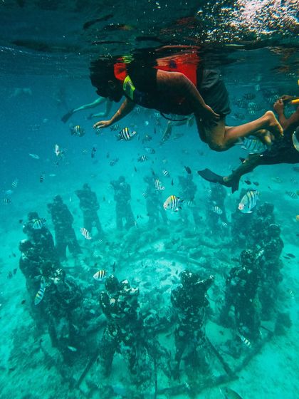 Swimming above the circle of statues at Gili Meno, surrounded by colorful fish. It feels like discovering a lost city.