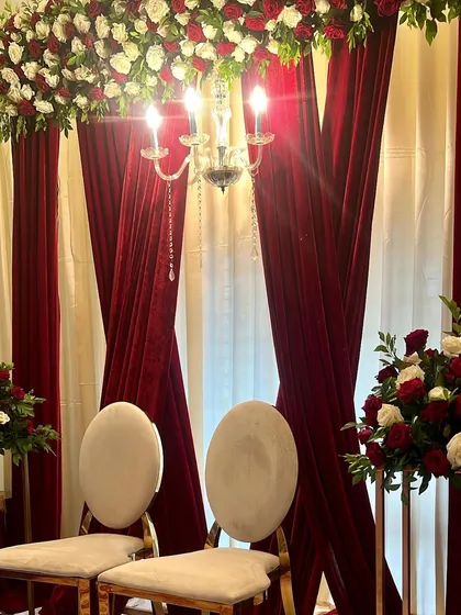 A close-up of the elegant seating and lighting for the Baat Pakki ceremony. The combination of velvet, roses, and crystal lighting creates a timeless and romantic feel.