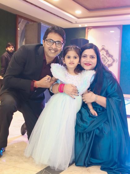 A happy family photo capturing a candid moment of affection between the parents and their daughter.