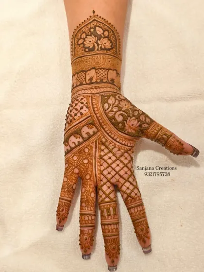 The palm of the other hand, filled with a mix of jaali (net) patterns and traditional motifs.