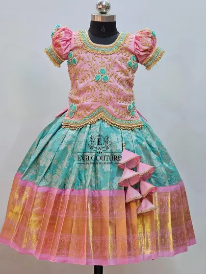 A beautiful pastel Kanchi Pattu lehenga. The pink blouse has delicate turquoise embroidery, matching the turquoise and pink brocade skirt.