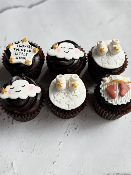 Welcoming a little one with these sweet "Twinkle Twinkle Little Star" themed cupcakes. I hand-sculpted each fondant topper, including the smiling clouds, tiny baby booties, and starry messages.