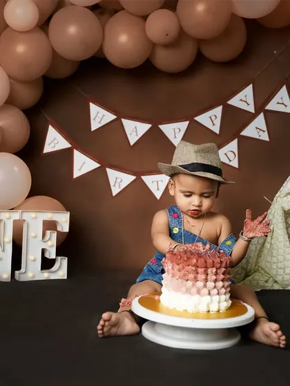 The first taste. This little guy is curiously poking at his first birthday cake, a moment of discovery and fun.