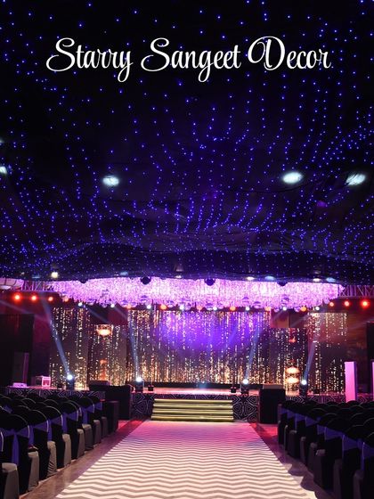 A wide shot of the "Starry Sangeet Decor," showing a ceiling covered in thousands of fairy lights, creating a breathtaking canopy of stars over the entire hall.