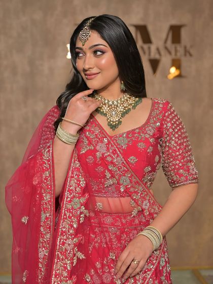 A complete bridal look featuring a heavy, gold-plated Kundan necklace, haath phool, and maang tikka, all available for rent.