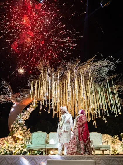 As fireworks light up the night sky, the couple shares a quiet moment on their wedding stage. We coordinate every element, including spectacular pyrotechnics, to create a grand finale for your ceremony.