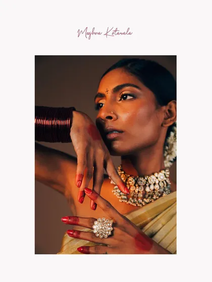 A powerful and expressive shot focusing on hands and jewelry. The traditional alta on the fingertips, the statement ring, and the layered necklace come together to create a portrait that is rich in culture and emotion.