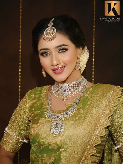 A smiling portrait of a South Indian style reception look. The makeup is flawless and bright, with a focus on enhancing the eyes and creating a luminous complexion.