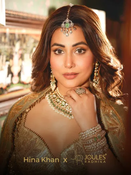 The radiant Hina Khan embodying the spirit of a modern bride in a complete JBR set. The look features a bespoke polki and pearl necklace, matching earrings, a maang tikka, and stacked kadas, all handcrafted to create a story of timeless elegance.