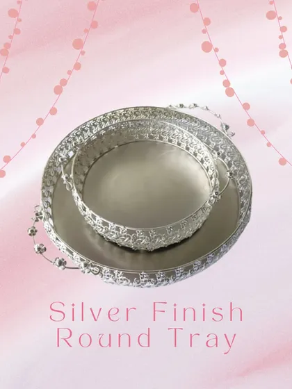 This silver-finish round tray is a versatile piece for any celebration. Its detailed filigree work makes it an elegant base for serving drinks, presenting gifts, or creating a hamper.