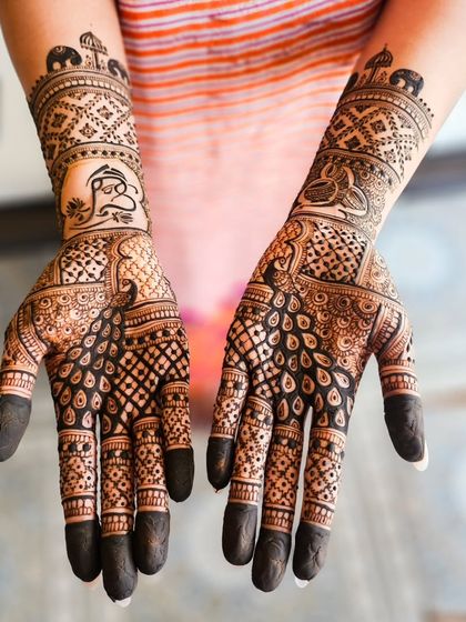 This engagement henna features a prominent Ganesha motif for blessings, surrounded by detailed grid work and paisleys.