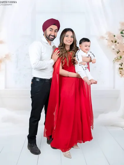This family portrait stands out with a bold splash of red. The mother's elegant gown and the happy baby create a truly memorable and stylish image.