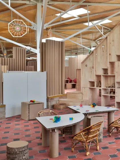 These images showcase the interior of the Atelier school, where partitions are made from recycled paper tubes. This innovative material choice is not only sustainable but also creates a playful, maze-like environment that encourages exploration and imaginative play.