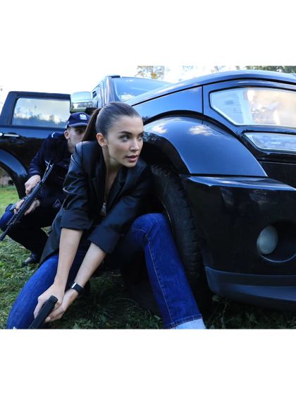 An action shot from 'CRAKK' featuring Amy Jackson. The styling here, including the practical jeans and jacket, was chosen to allow for maximum mobility during stunt work.