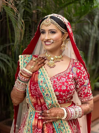The beauty of a traditional Gujarati bride. The makeup is designed to complement the vibrant colors of her 'Panetar' saree.