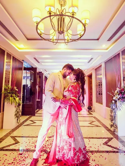 A dramatic, wide-angle shot of a couple in a beautifully lit hotel corridor. I use architectural elements and perspective to frame the couple, creating a grand and romantic portrait that feels like a scene from a movie.