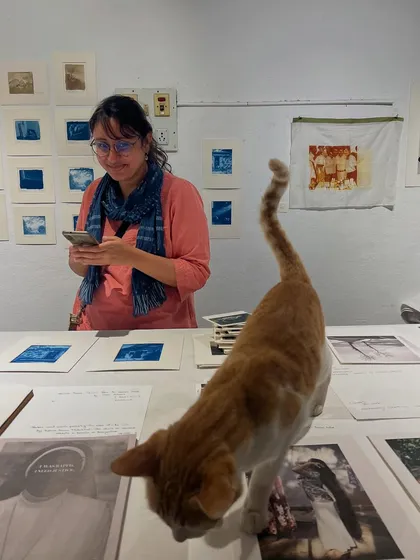 A candid moment from one of our bustling print sales, complete with our resident cat and quality inspector, Julie. These events are the heart of our community, helping us fund new projects and make art accessible to everyone.