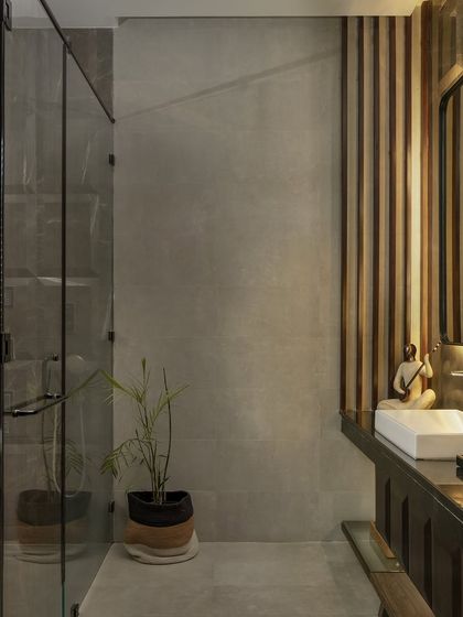A detail of the organic warm bathroom, showing a small sculpture and plant. The design focuses on creating a serene, natural atmosphere.