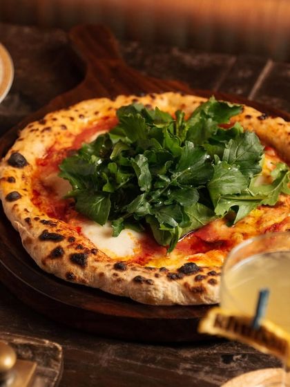 Whether you're craving the cheesy goodness of pizza, the artistry of sushi, or a bite of dim sum, I have it all. Here, our fresh arugula pizza is ready to be devoured.