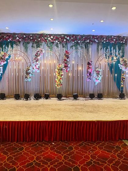 Another stunning stage design at Sky banquet hall, featuring hanging floral arrangements and a colorful backdrop. This setup is perfect for a vibrant sangeet or reception.