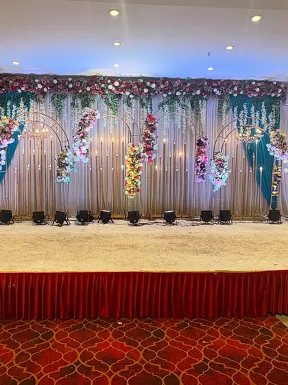 A creative stage design featuring hanging floral arrangements and unique lighting. This setup at Sky banquet hall in Kharghar is perfect for a sangeet or reception party.