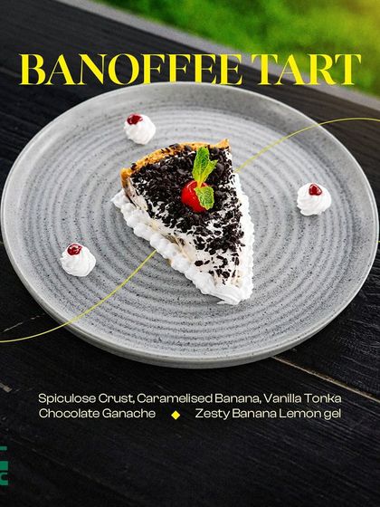 A slice of our decadent Banoffee Tart, featuring a speculoos crust, caramelized banana, and chocolate ganache.