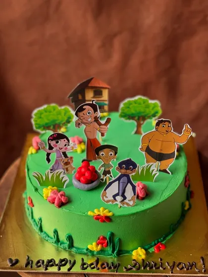 A Chota Bheem themed cake, bringing the popular Indian cartoon to life. The vibrant green buttercream sets the scene for Bheem and his friends.