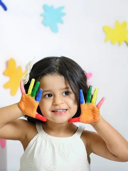 A close-up of our little Picasso. Her happy expression and colorful hands perfectly capture the fun and creativity of this art-themed session.