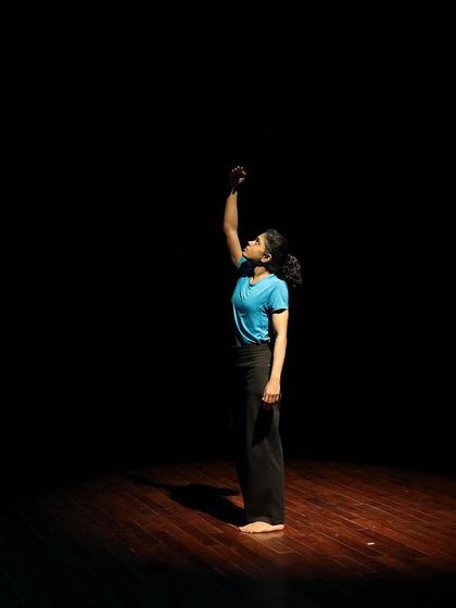 A dancer reaches up during a tech run.