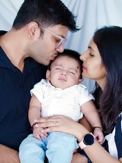 A tender moment as parents kiss their sleeping newborn. These are the family heirlooms we love to create.