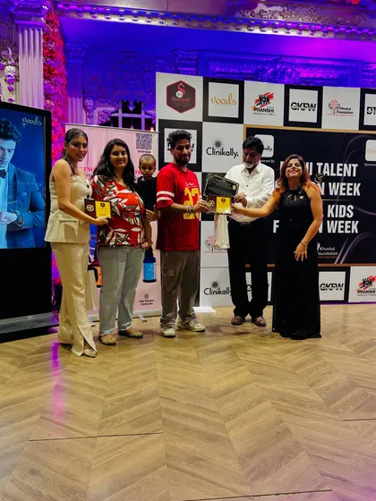 The event organizers and jury present awards to participants. The media wall, covered in sponsor logos, serves as the background for all official photographs, ensuring continuous brand exposure.
